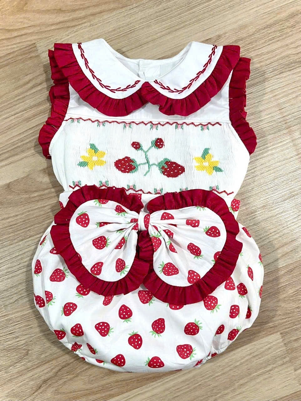 Red “Berry Sweet” Sleeveless smocked romper.